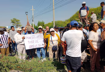 Rice farmers protest by blocking roads and displaying a sign demanding a fair price for rice, within the framework of a national agricultural strike.